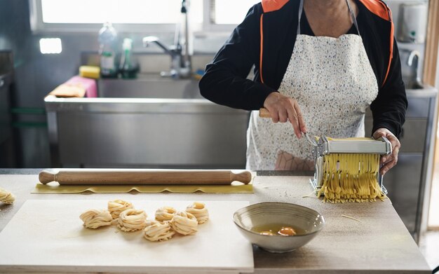 Kobieta pracująca w fabryce makaronu - Świeży tradycyjny włoski makaron i koncepcja małej firmy