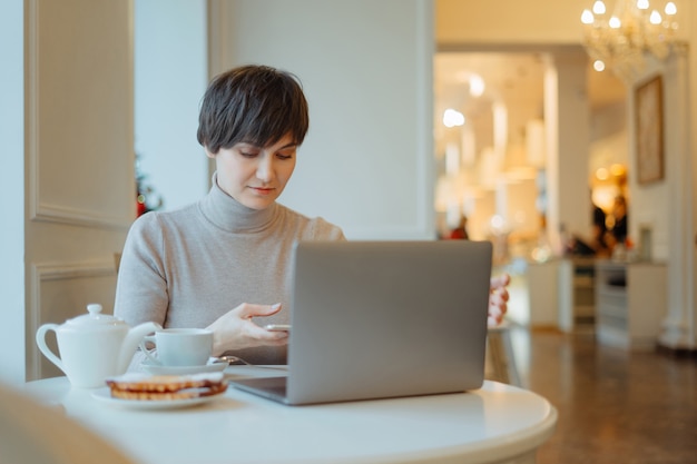 Kobieta pracuje na komputerze w kafejce internetowej