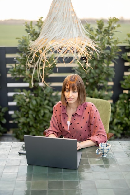Kobieta pracuje na laptopie online w ogrodzie na świeżym powietrzu