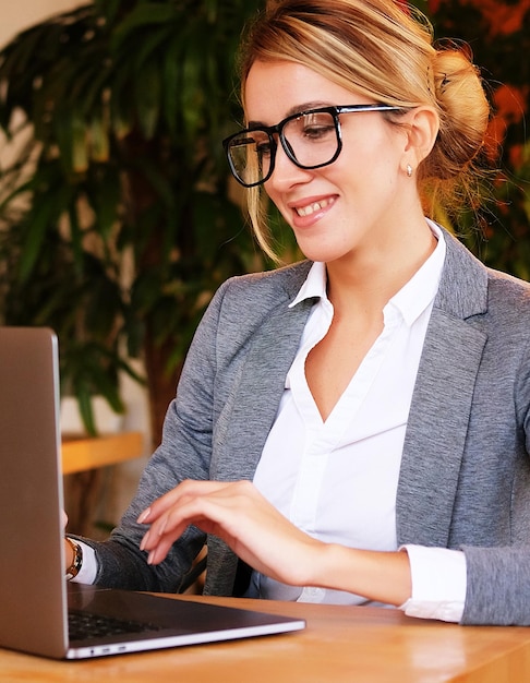 Zdjęcie kobieta pracuje na laptopie w kawiarni młody biznes w