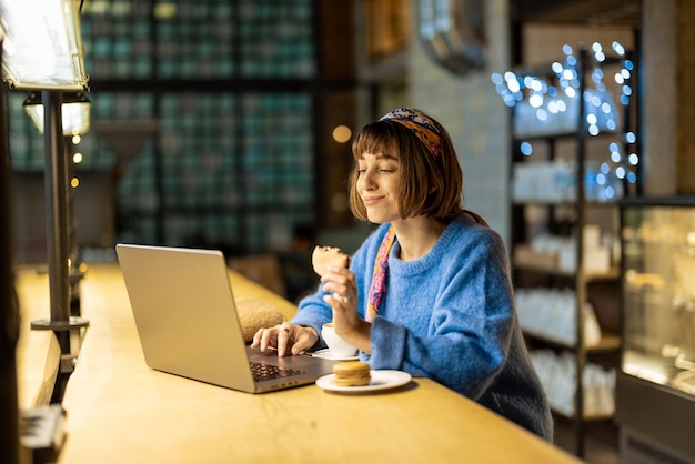 Kobieta pracuje na laptopie w kawiarni