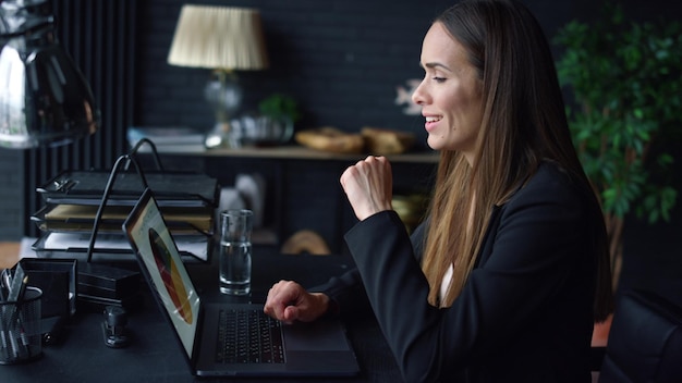 Kobieta pracuje na laptopie w miejscu pracy Kobieta pisze na laptopie w biurze