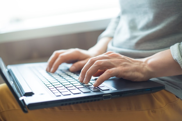 Kobieta pracuje na laptopie. Zbliżenie klawiatury i rąk. Wolny zawód.