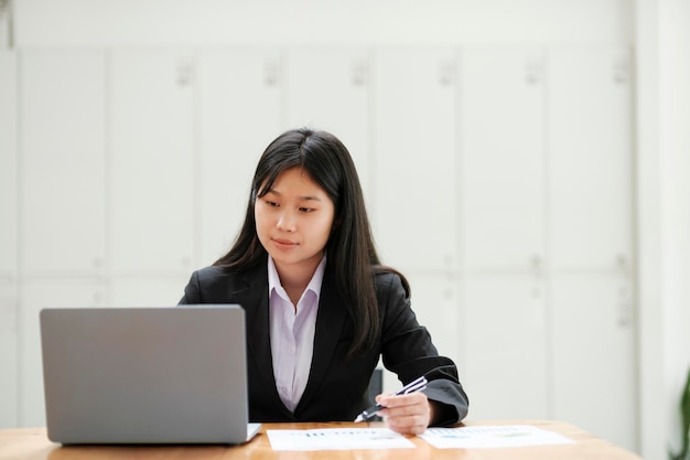 Kobieta pracuje w biurze przy użyciu laptopa