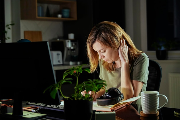 Kobieta pracuje w domowym biurze zdalnie przy użyciu komputera
