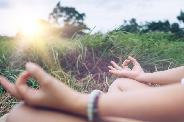 Zdjęcie kobieta praktykuje lekcję jogi, oddychanie, ćwiczenia medytacyjne, odkryty w trawie. dobre samopoczucie, koncepcja wellness