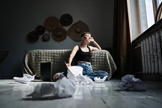 Zdjęcie kobieta profesjonalna autorka treści pracująca z dokumentami i laptopem w domu, siedząc na