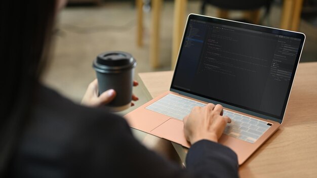 Kobieta programistka pracująca nad programowaniem projektów stron internetowych na komputerze stacjonarnym w firmie startowej