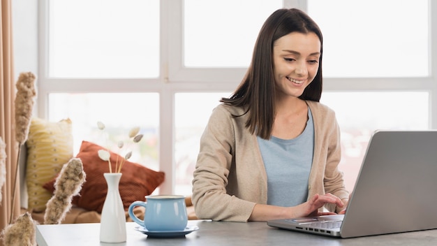 Kobieta przy biurkiem pracuje na laptopie