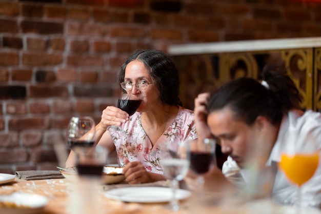 Kobieta przy lampce wina na uroczystości rodzinnej w restauracji