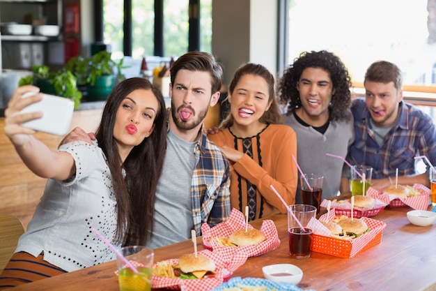 Kobieta przy selfie z przyjaciółmi w restauracji