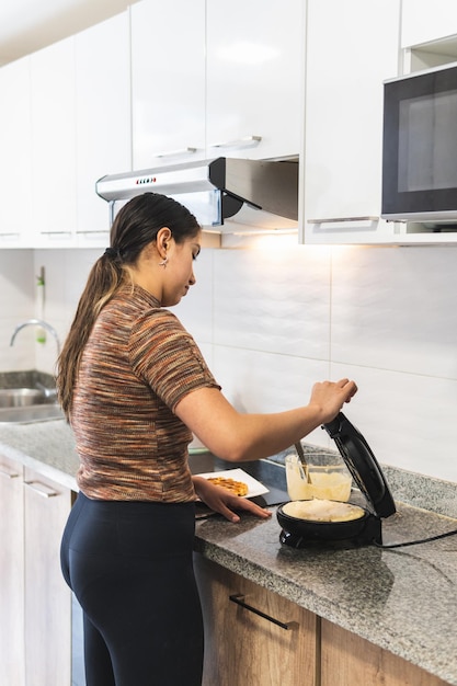 Kobieta przygotowuje gofry w kuchni