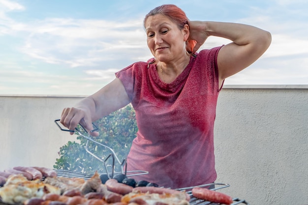 Zdjęcie kobieta przygotowuje jedzenie na grillu