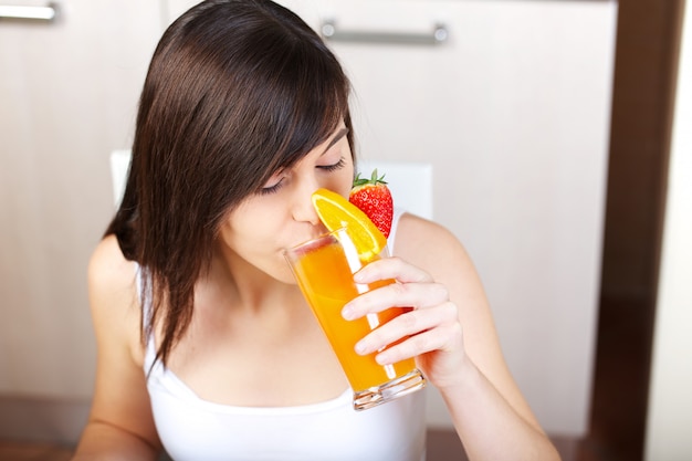 Kobieta przygotowuje sok owocowy z wyciskaczem