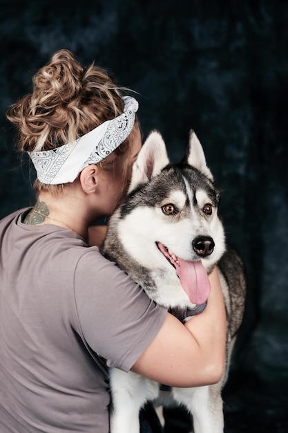 Zdjęcie kobieta przytulająca psa z chustką na głowie