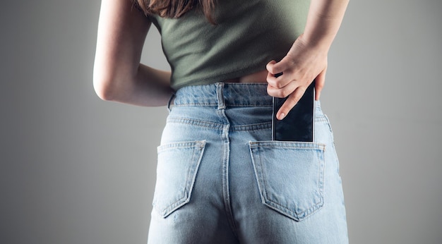 Kobieta ręka telefon w tylnej kieszeni dżinsów
