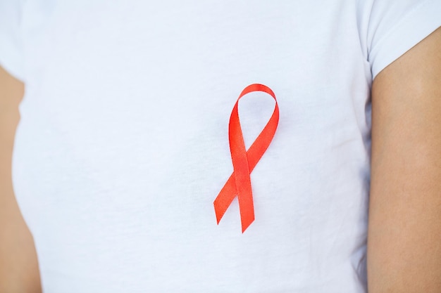 Kobieta ręka trzyma czerwoną wstążkę Świat HIV wstążka świadomości dnia AIDS