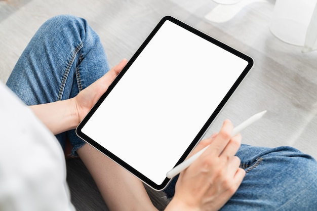 Zdjęcie kobieta ręka za pomocą cyfrowego tabletu i ekran jest pusty.