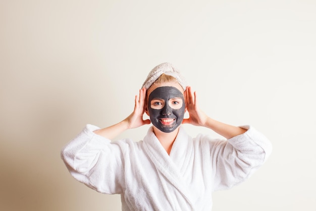 Kobieta relaksująca się z czarną maską spa na twarz w salonie kosmetycznym