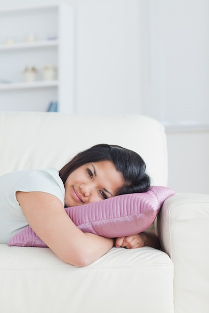 Kobieta relaksuje na kanapie z jej głową na poduszce