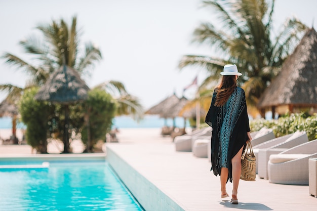 Kobieta relaksuje przy basenem w luksusowym hotelowym kurorcie cieszy się idealnego wakacje na plaży wakacje