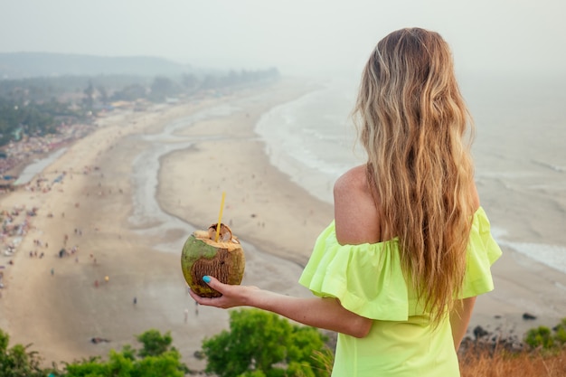 Kobieta relaksuje się na szczycie góry z widokiem na plażę