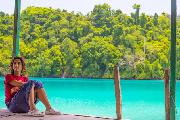 Kobieta relaksuje w miejscowości turystycznej na kolorowym morzu dalekie Togean wyspy, Sulawesi, Indonezja.