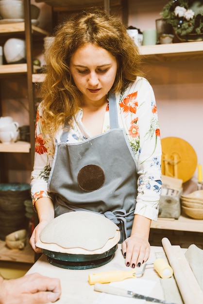 Kobieta robi ceramicznemu garncarstwu na warsztacie. Pojęcie dla kobiety w freelance, biznes. Rzemiosło