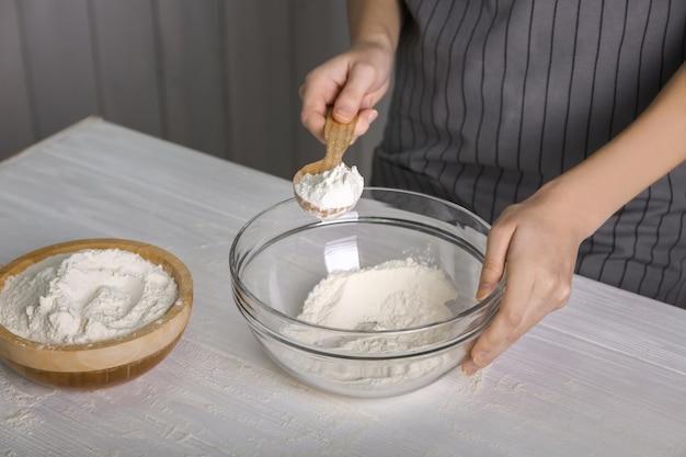Kobieta robi ciasto na kuchennym stole