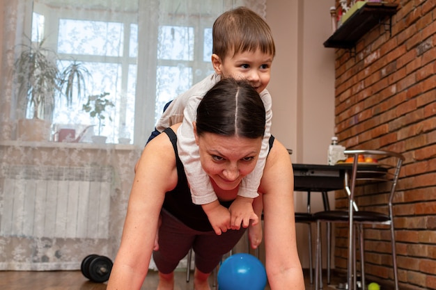 Kobieta robi ćwiczenia fitness z dziećmi w domu