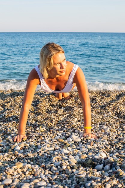 Kobieta robi ćwiczenia na plaży