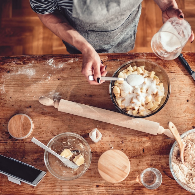 Zdjęcie kobieta robi jabłczanemu ciastu na drewnianym stole