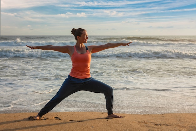 Kobieta Robi Joga Asana Virabhadrasana 1 Warrior Pose On Beach On