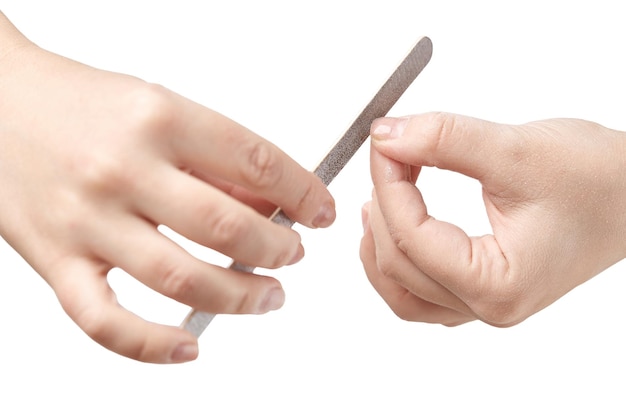 Kobieta robi manicure w domu, spiłując długość paznokci pilnikiem do paznokci