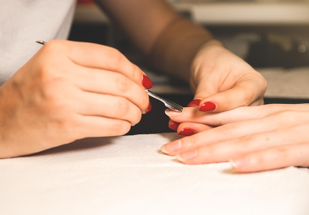 Kobieta robi manicure Zabiegi w salonie w domu Piękne dłonie i paznokcie