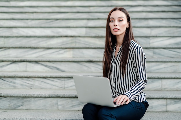 Kobieta robi niezależnej pracy na laptopie na zewnątrz