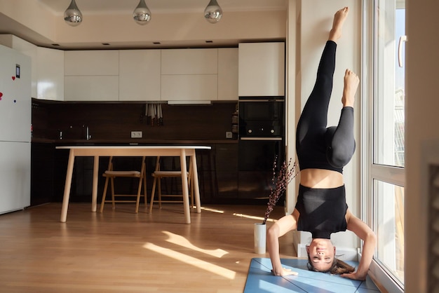 Kobieta robi pozę jogi z nogami w górę