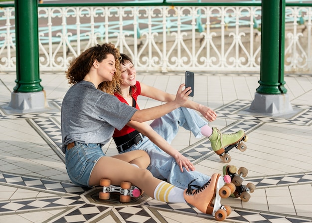 Kobieta robi selfie z przyjaciółką na wrotkach na świeżym powietrzu