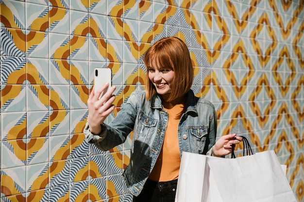 Kobieta robi selfie z torbami na zakupy