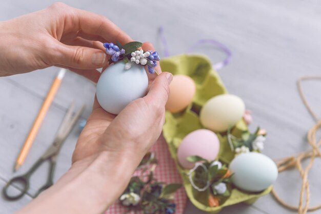 Kobieta robi słodkie ozdobne jajka na święta wielkanocne. koncepcja prezentów wielkanocnych zrób to sam. słodkie pastelowe kolorowe jajka