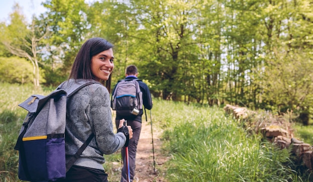 Kobieta robi trekking patrząc na kamery