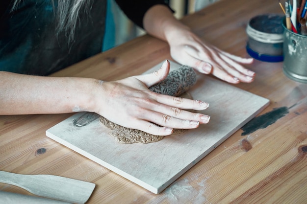 Kobieta robi wzorowi na ceramicznym talerzu