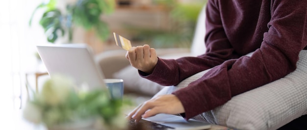 Kobieta robi zakupy online Dziewczyna robi zakupy za pomocą laptopa i karty kredytowej do płatności w domu.