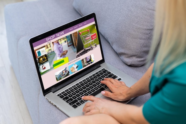 Kobieta robi zakupy online za pomocą swojego laptopa w domu.