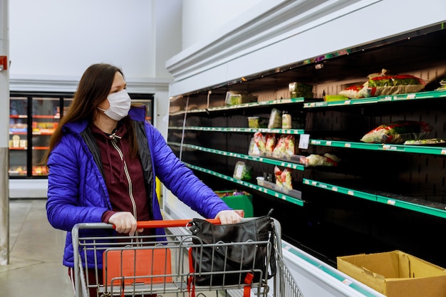 Kobieta Robi Zakupy Przy Supermarketem Z Ochrony Twarzy Maską I Rękawiczkami.