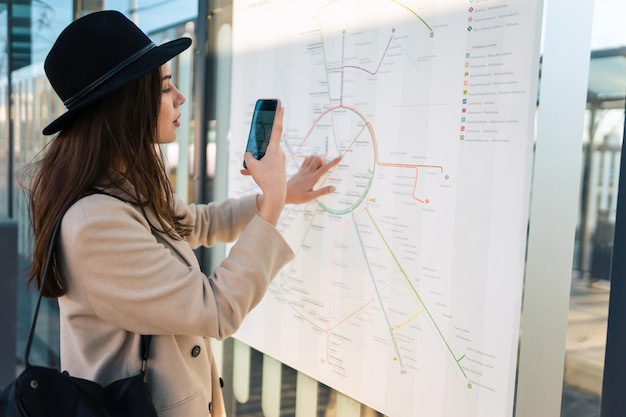 Kobieta robi zdjęcie mapy tras transportu publicznego