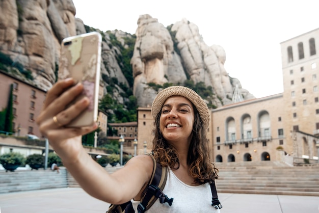 Kobieta robi zdjęcie selfie w klasztorze montserrat, Barcelona, Hiszpania