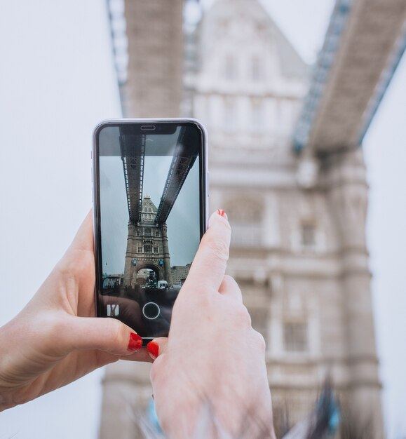 Kobieta robi zdjęcie Tower Bridge w Londynie. Koncepcja podróży, zwiedzania