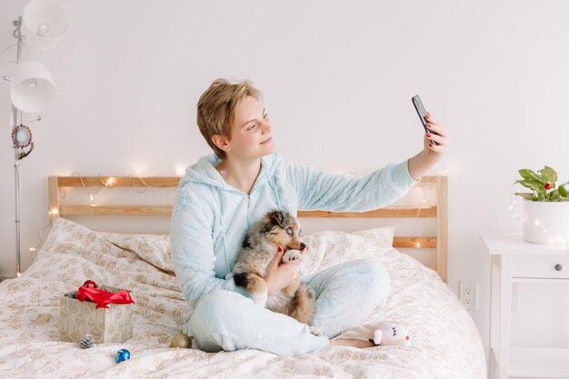 Kobieta robiąca selfie z uroczym szczeniakiem na smartfonie