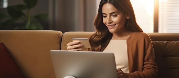 Kobieta robiąca zakupy online uśmiecha się z laptopem na kanapie w domu